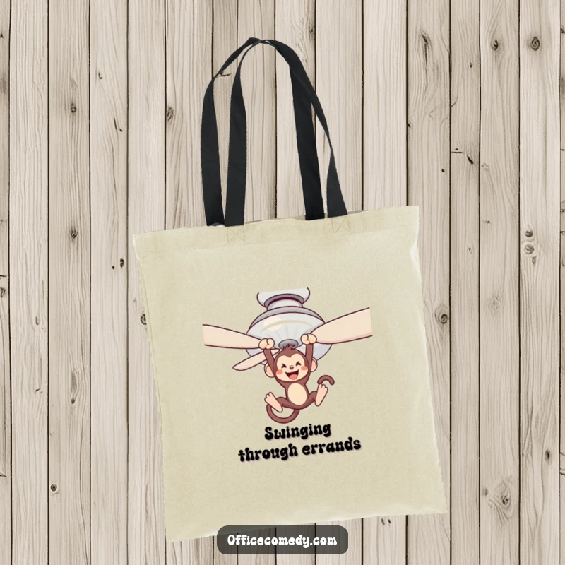 Funny tote bag showcasing a monkey swinging from a ceiling fan blade, ideal for carrying essentials with a playful spirit.